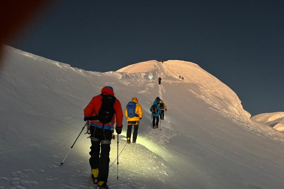 Climbers making their summit push on Mera Peak as the sun rises above the Himalayas